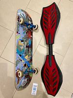 Both skateboard bottom side with colorful geometric graphic and Ripstick red and black placed next to each other.