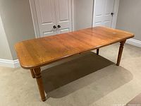 Full view of solid oak dining table with legs attached, rectangular shape, medium oak finish.