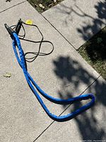 Blue insulated heat traced water hose laid out on a concrete surface showing full length and connectors.