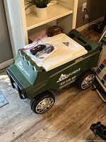 Full view of remote-controlled green Coors Light cooler with white lid, wheels, and remote control on top.