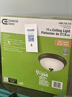 Photo of the commercial electric LED ceiling light box showing product specifications including 11-inch size and oil-rubbed bronze finish.