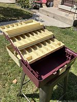 Opened plano 3300 tackle box showing three tiered beige compartment trays, each with multiple sections for organizing tackle.