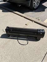 Side angle showing the heater body, mesh grill, power cord, and one end with control knobs.