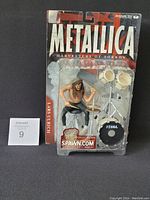 Figurine and drum kit in original sealed packaging with Metallica branding and collectible stickers