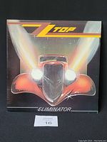 Front cover of the ZZ Top Eliminator vinyl record showing a stylized red vintage car with bright headlights on a dark background.