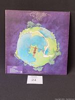 Front side of the Yes 'Fragile' vinyl record gatefold cover. Shows a colorful globe with detailed artwork on a purple background.