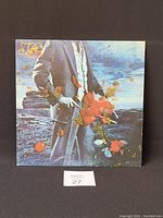 Front cover of Yes vinyl record showing man in suit holding red roses in surreal landscape