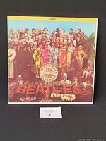 Front cover of the Sgt. Pepper's album showing the colorful array of figures positioned around the central drum bearing the album title.