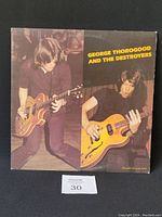 Front cover of the George Thorogood and the Destroyers vinyl record showing two musicians playing electric guitars with band name in yellow text.