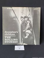Front cover of The Rolling Stones "December's Children (And Everybody's)" album in black and white with band photo.