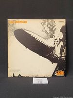 Front cover of Led Zeppelin's debut album showing the Hindenburg airship disaster image with the band's name in orange lettering at top left and Atlantic logo bottom right.