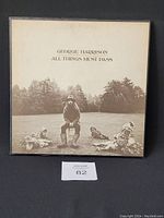 Front view of George Harrison All Things Must Pass vinyl album cover showing sepia-tone photo with garden gnomes and George Harrison seated.