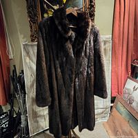 Full front view of the vintage brown fur coat showing glossy fur, classic collar, and long sleeves.