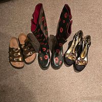 Three pairs of women's footwear: bronze buckle sandals, knee-high boots with red lips pattern and animal print high heels.