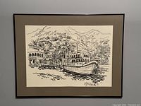 Framed black pen drawing print titled "Island Life." Shows a harbor with boats and buildings on a hill. Matted in tan and framed in black under glass.