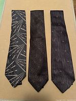 Three vintage Armani ties laid flat showing different patterns and textures