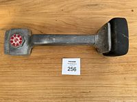 Full view of the knee kicker tool showing padded striking surface, handle, and red adjustment knob.