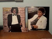 Front covers of Off the Wall and Thriller albums displayed side by side against a gray wall.