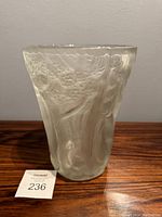 Frosted art glass vase with forest motif viewed frontally, showing textured trees and foliage in relief.