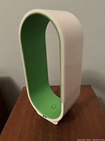 LED desk lamp with unique open rectangular loop shape, white outside and green inside with USB power cord.