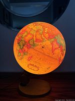 Illuminated globe glowing showing continents Africa, Europe, Asia with antique-style map colors.