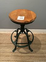 Front view of round wooden seat atop green cast iron base
