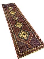 Full view of the Persian Kerman runner rug showing geometric diamond motifs with floral designs and multi-tone borders.