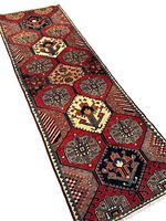 Full view of runner rug on wood floor showing overall design, colors and fringe