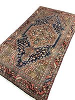 Full view of rug at an angle showing entire geometric medallion and border design