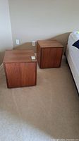 Pair of cube bedside cabinets positioned next to bed and wall.