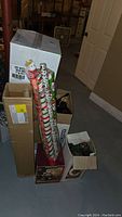 Overall view of stacked boxes with rolls of Christmas-themed wrapping paper and boxes labeled for lighting and extensions