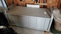 Full front and side view of the metal deck storage box in a shed environment, showing size and construction.
