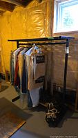 Front view of the garment rack with some clothes hanging to show scale and condition