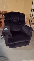 Front view of black La-Z-Boy recliner chair showing plush cushioned backrest, padded armrests, and comfortable seat cushion with hand control on the side.