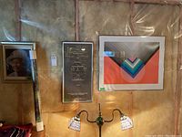 Photo showing four art prints: one unframed, three framed, one frame visibly damaged. Prints include portrait and abstract art.