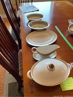 Photo showing the set of Royal Doulton English Renaissance pattern serving ware arranged on wooden table including covered tureen, gravy boat, platter, and bowl.