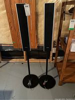 Pair of Sony SS-TS82 tower speakers on black round stands shown from perspective, highlighting overall design and dimensions.