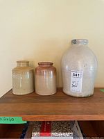 All three jars shown on a wooden surface, varying in size and glaze color