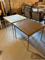 View showing both folding card tables side-by-side, materials and colors visible