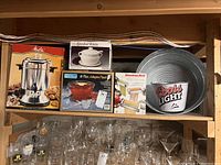 Top shelf shows boxed Melitta coffee urn, Himark ceramic tureen, Anchor punch bowl set, and additional items not included.