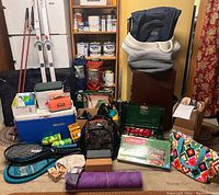 Full lot showing camping stove, coolers, bags, tennis rackets, yoga mat, dice, and various accessories.