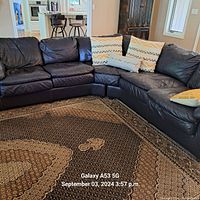 L-shaped view of two-section dark brown leather sectional sofa in living room