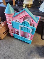 View of pink and teal Barbie Dreamhouse showing the turret and side architectural details.