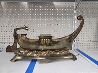 Side front angle showing the Viking ship figurine's dragon head prow, glass insert, and wave base