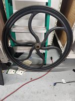 Front view of large 34-inch cast iron flywheel showing six curved spokes and the rim.