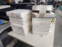 Two stacks of 13 styrofoam boxes containing the plates, showing packaging condition and quantity.