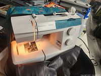 Sewing machine seated in its soft case, power on, front view showing work area