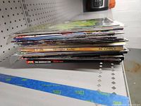 Stack of comic books laid flat showing edges and varying thicknesses.