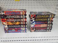 Front view of two stacks totaling 13 VHS tapes in original Neon Genesis Evangelion slipcases showing spine artwork