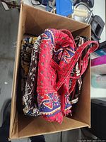 Four purses in a box showing three multi-patterned Vera Bradley bags and one red paisley purse